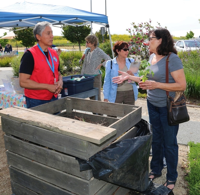 A Master Gardener explains composting to a local resident.