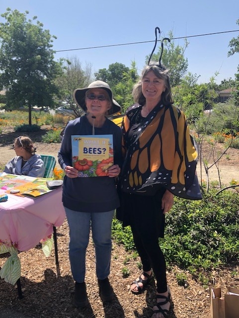 Denise is holding a book about bees, and Rhonda is dressed like a monarch butterfly.