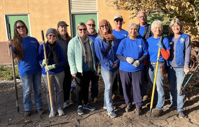 Group of 11 Master Gardeners holding tools and smiling.