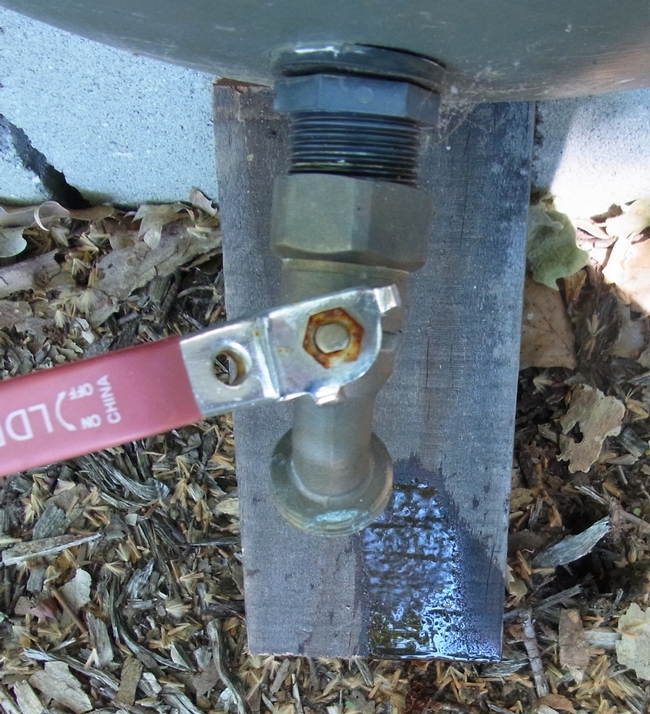 Bee board with a slow drip of water from a rain barrel