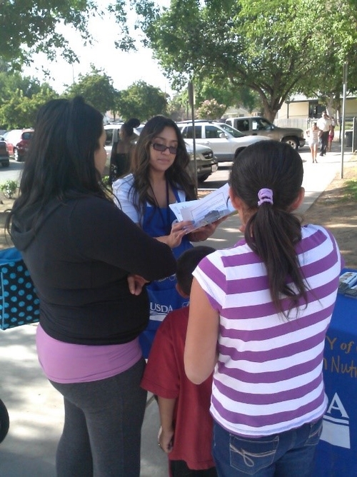 Consuelo Cid teaches a family at Burroughs Elementary about a Healthy Plate.