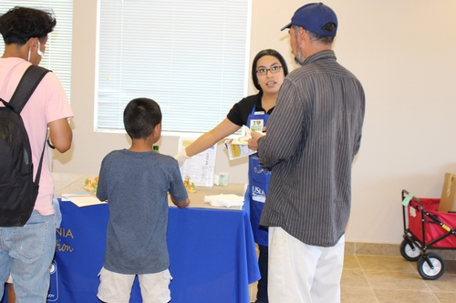Community members visit the information booth to learn about choosing healthy snacks