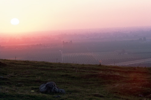 Orchards and a colorful sunset viewed through smoggy air.