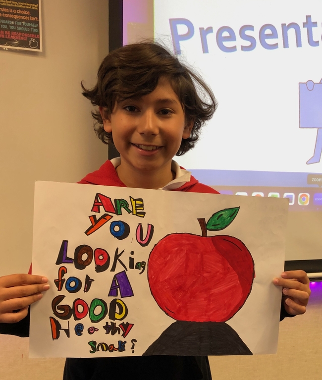 Hillview student Jacob Ponce holding up his poster after presenting it to the class.