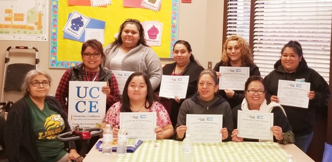 Elia Escalante (holding the UCCE board) with her participants who graduated from CFHL, UC program received certificate of completion.