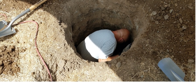 A person standing in a deep hole.