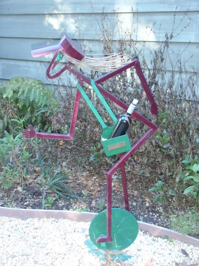 Sculpture of a Unicyclist Toting a Wine Bottle.