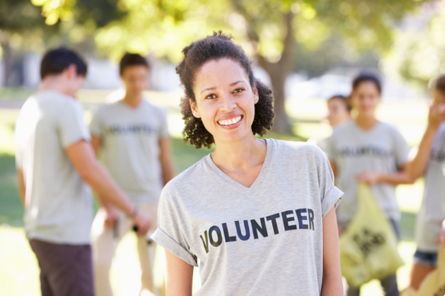 A woman in a grey t-shirt that says VOLUNTEER on it.