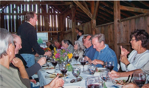 People eating farm dinner in barn