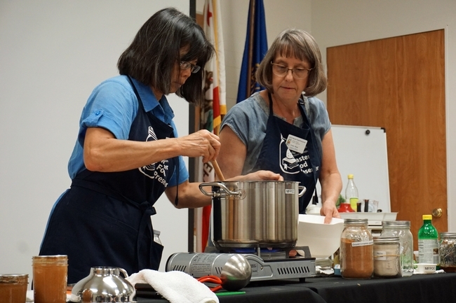 La coordinadora del programa de Conservadores Maestros de Alimentos de UC en el condado de Orange, Cinda Webb, derecha y Mabel Alazard, Conservadora Maestras de Alimentos, preparan mermelada de persimo.