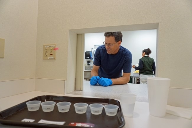 El técnico de USDA, Paul Neipp, presenta una bandeja para las pruebas de agua con limón en una de las estaciones del laboratorio sensorial.