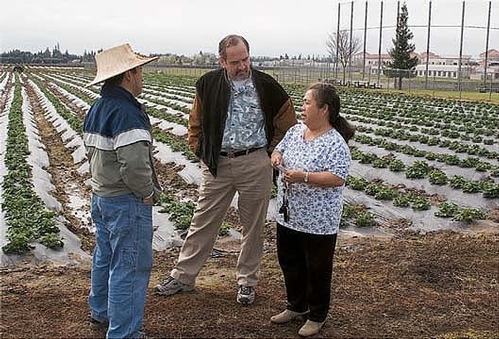 Michael Yang, left, and Richard Molinar talk to a Southeast Asian farmer.