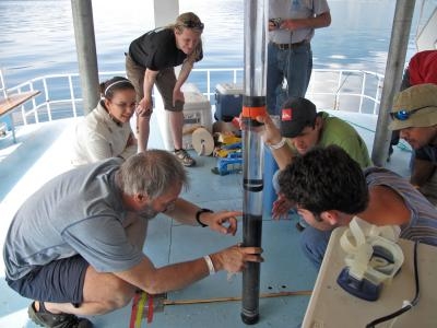 Researchers and students examine a sediment core sample from the bottom of Lake Atitlan.