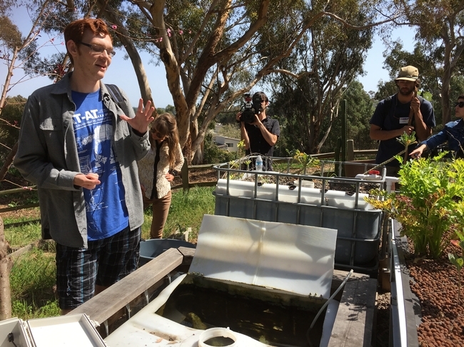 A UCSD student discussed a closed-circuit aquaponic system created at Roger's Garden. Multiple UCSD students as well as GFI fellows conduct research projects in the garden with the goal of replicating and scaling to gardens outside of UCSD and in the community.