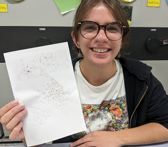 Hanna Briggs, a UC Davis transfer student, holds a sample card showing how glitter mimics insects. She is an intern in the laboratory of arachnologist Jason Bond, the Schlinger Endowed Chair, UC Davis Department of Entomology and Nematology, and associate dean, College of Agricultural and Environmental Sciences.