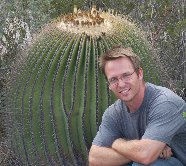 Alex Van Dam, photographed next to a giant cactus.