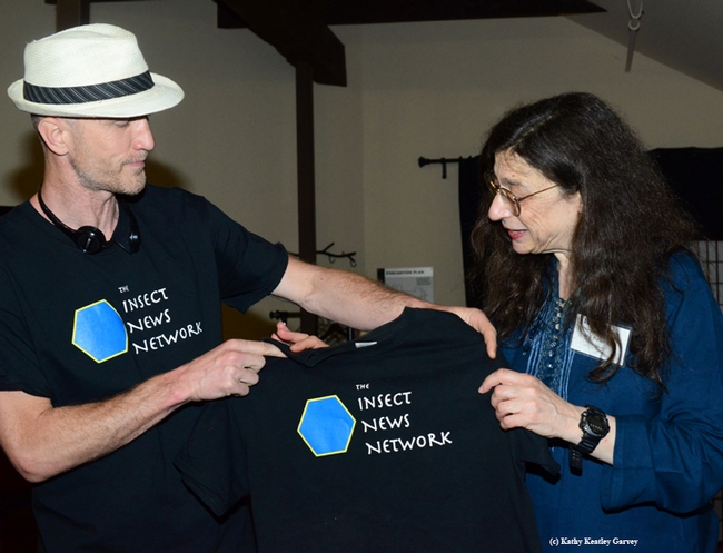 Emmet Brady, shown here with May Berenbaum, talks about the meaning of the Insect News Network t-shirt. (Photo by Kathy Keatley Garvey)