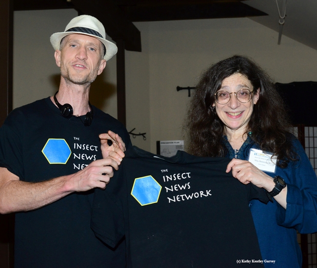 Emmet Brady presents May Berenbaum with an Insect News Network t-shirt. (Photo by Kathy Keatley Garvey)