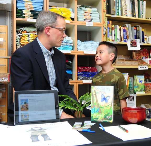 Joel Fuerte, 6, of Woodland, eagerly listens to children's author S. S. Dudley, a retired UC Davis scientist. (Photo by Kathy Keatley Garvey)