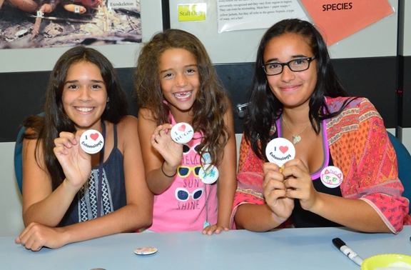 The Nansen sisters (from left) Emma, 12, Molly, 6, and Miriam, 15, of Davis display entomology buttons. They helped visitors create buttons. Their mother, Maria, is a volunteer at the Bohart, and their father, Christian, is a UC Davis entomologist. (Photo by Kathy Keatley Garvey)