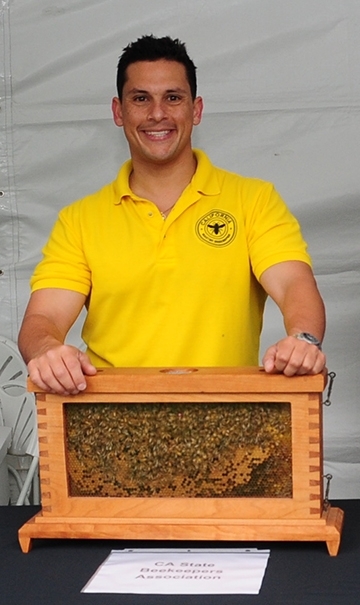 Bernardo Niño of the Harry H. Laidlaw Jr. Honey Bee Research Facility, UC Davis, displays a bee observation hive. This photo was taken at the California State Beekeepers' Association booth at the recent California Agriculture Day at the State Capitol. (Photo by Kathy Keatley Garvey)