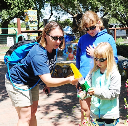 UC Davis Athletics employee Nicole Morrill admires a bee caught by her daughter, Samantha, 8, as sister Hannah, 11, watches.