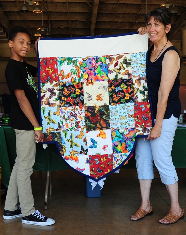 Back: Gloria Gonzalez, superintendent of McCormack Hall, Solano County Fair, and her assistant Ian Mayhew, 12, of American Canyon, display the back of LaQuita Tummings' quilt. (Photo by Kathy Keatley Garvey)