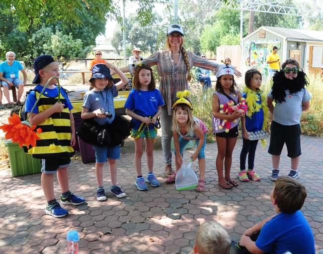 After Sarah the Bee Girl (back) read a book about bees, she quizzed them, and those with the correct answers were given  props depicting those bees. These youngsters represent (from left) a  forager, a scout bee, a house bee, a nurse bee, the queen bee and a drone. (Photo by Kathy Keatley Garvey)