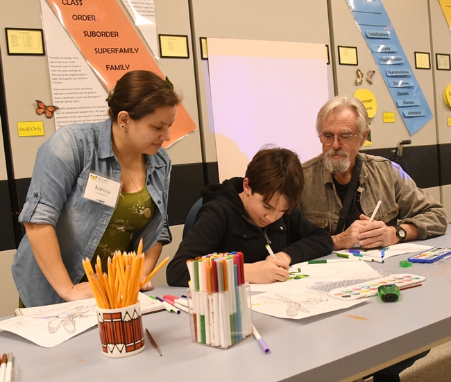 UC Davis student/artist Karissa Merritt talks about art with James Harris, 13, and his father, Rick Harris, who holds a master's degree in systemic entomology from UC Davis. (Photo by Kathy Keatley Garvey)