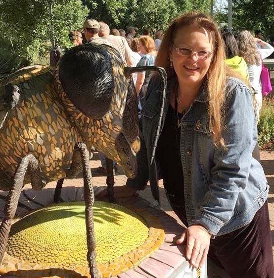 Beekeeper Sharon Schmidt stands next to the sculpture, 
