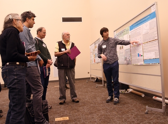 UC Davis doctoral student John Mola explains his research to the judging panel. From left are Mea McNeil, timer; Santiago Ramirez of the UC Davis Evolution and Ecology faculty; Tom Seeley of Cornell, the keynote speaker at the symposium; and Robbin Thorp, distinguished emeritus professor of entomology at UC Davis. (Photo by Kathy Keatley Garvey)