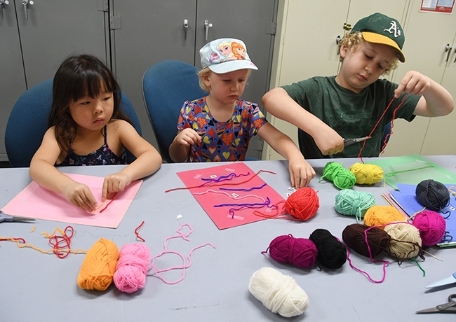 Participating in the family craft activity are (from left) Vacaville residents Rinka Matsumiya, 5,  Kate Irwin, 3,  and Kate's brother, Thomas Irwin, 8. (Photo by Kathy Keatley Garvey)