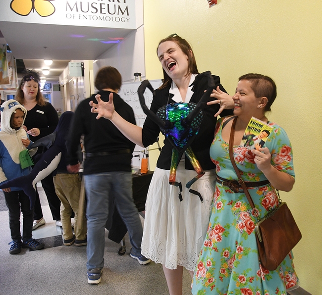 UC Davis undergraduate entomology student Karissa Merritt (right) who created the invitations, shares a laugh with doctoral candidate Charlotte Herbert Alberts, who crafted her costume, inspired by  the invitation. (Photo by Kathy Keatley Garvey)