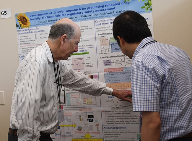 Research posters were a key attraction at the Hammock lab reunion. Here Bruce Hammock discusses one of the posters. (Photo by Kathy Keatley Garvey)