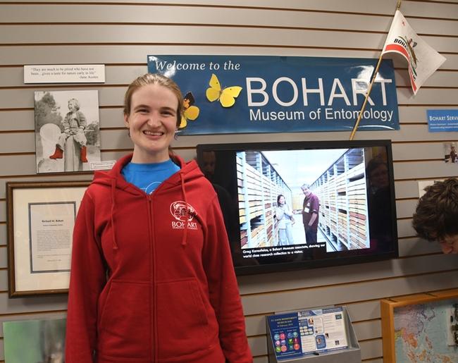 Entomologist/artist Charlotte Herbert Alberts wearing a red hooded sweatshirt: front view showing the Bohart logo and a tardigrade face. (Photo by Kathy Keatley Garvey)
