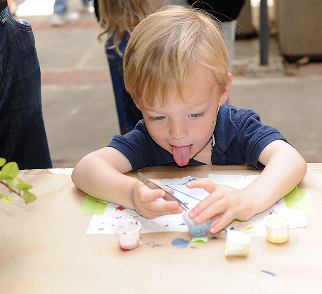 This youngster gives it his all at the maggot art table at Briggs Hall. (Photo by Kathy Keatley Garvey)