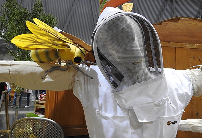 A gigantic honey bee on the arm of a beekeeper mannequin in Building B of the California State Fair. (Photo by Kathy Keatley Garvey)