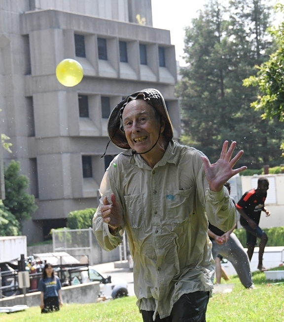 Bruce Hammock engaging in his annual water balloon battle on the lawn of Briggs Hall, UC Davis. (Photo by Kathy Keatley Garvey)