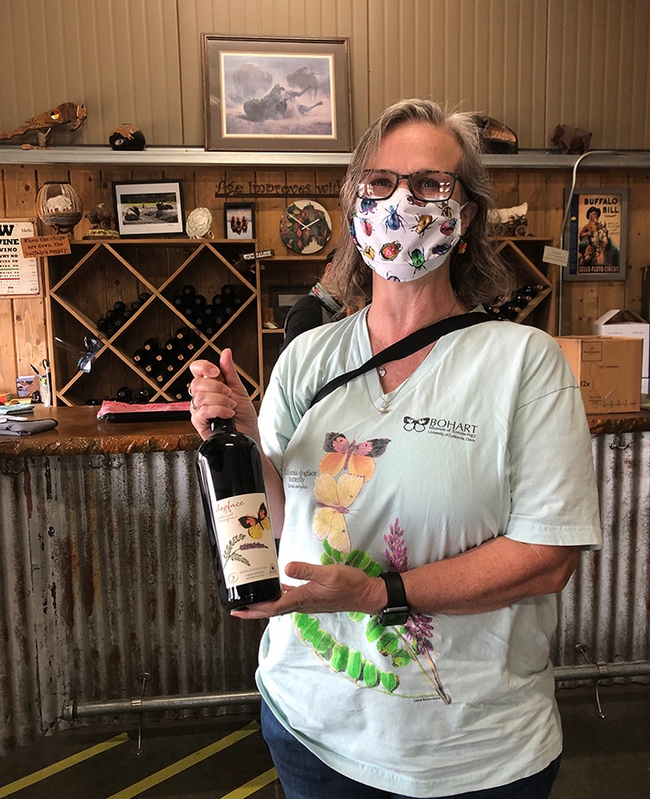 Professor Fran Keller of Folsom Lake College with a bottle of Dogface Cabernet Sauvignon produced by Lone Buffalo Vineyards and Winery, Auburn. Sales of the wine help conservation efforts of Placer Land Trust to protect the butterfly, the California state insect.