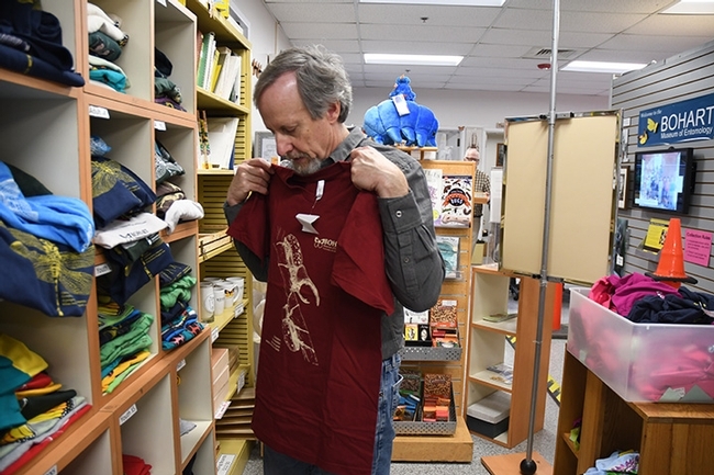 Senior museum scientist Steve Heydon checks out a t-shirt in the Bohart Museum gift shop; image taken prior to the COVID-19 precautions. (Photo by Kathy Keatley Garvey)