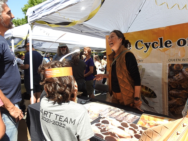 Karen Kiyo of Berkeley, member of the California Master Beekeeper Program, shares a laugh at the CAMBP educational table. (Photo by Kathy Keatley Garvey)