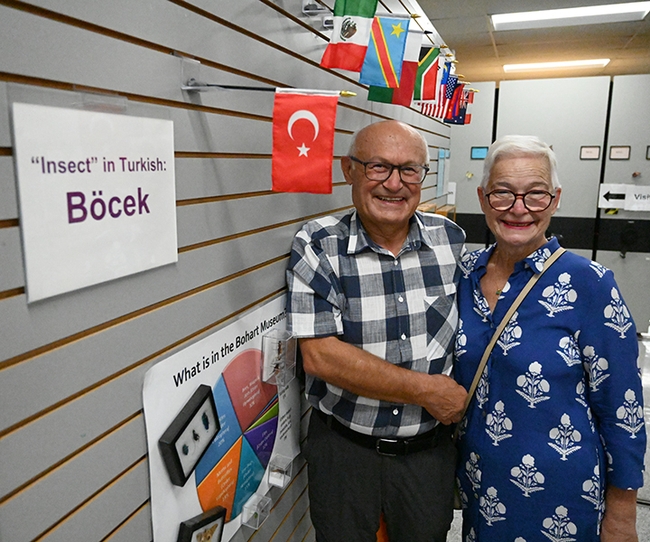 At the Bohart Museum of Entomology, Dr. Ismail Seker and his wife, Esin, stand in front of the Turkish flag and a card indicating how to say 