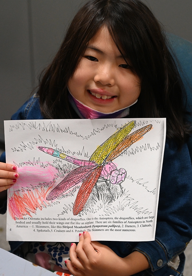Lena Yu, 7, of Sacramento shows the page she colored. (Photo by Kathy Keatley Garvey)