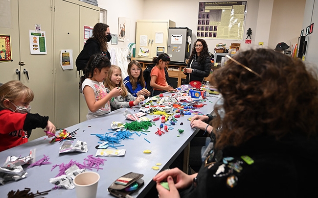 With UC Davis students (right) assisting at the Bohart Museum arts-and-crafts table, artists create arthropods and other critters, using modeling clay. (Photo by Kathy Keatley Garvey)