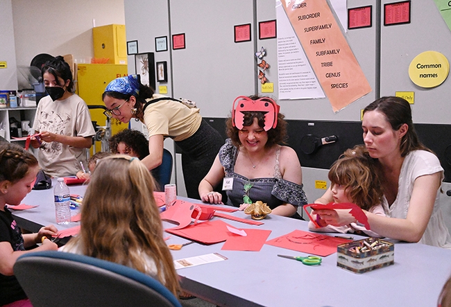 UC Davis first-year entomology student Kat Taylor (in ant headgear) staffed the arts-and-crafts table at the Bohart Museum open house. (Photo by Kathy Keatley Garvey)