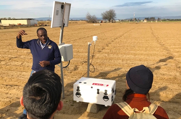Isaya Kisekka explains to students how the small footprint cosmic ray measures soil water over a range of scales at the UC Davis research farm.