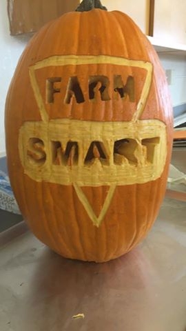 A picture of the pumpkin with the FARM SMART logo carved into it.