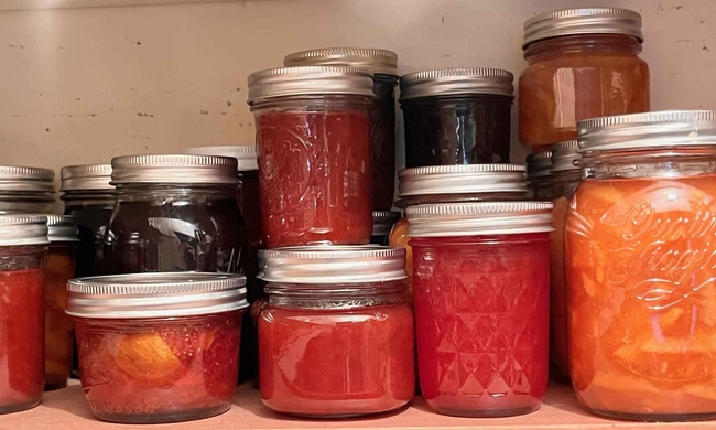 Jars of jams, jellies, and chutneys in a well-stocked pantry. J.C. Lawrence