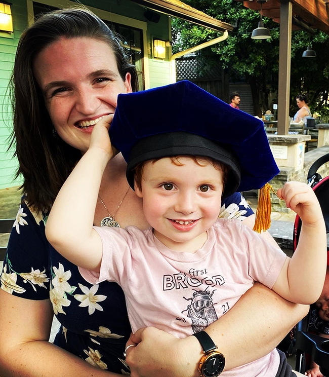 Griffin Alberts, 3, shown here with his mother, Charlotte Herbert Alberts, a new PhD, tries on 