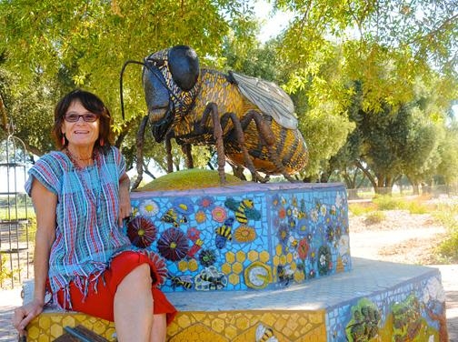 Donna Billick with her bee sculpture, which anchors the Haagen-Dazs Honey Bee Haven on Bee Biology Road, UC Davis. (Photo by Kathy Keatley Garvey)